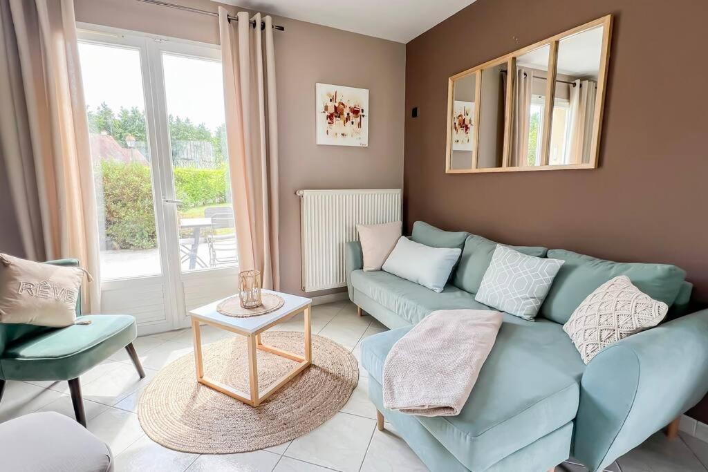 un salon avec un canapé bleu et une table dans l'établissement La maison d'Anne, à Saint-Arnoult