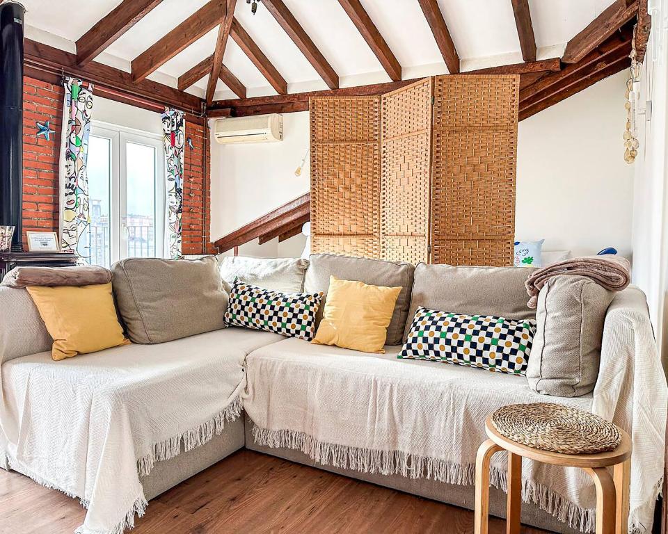 a living room with a couch with pillows on it at Acogedor loft con vistas a la ciudad in Santander