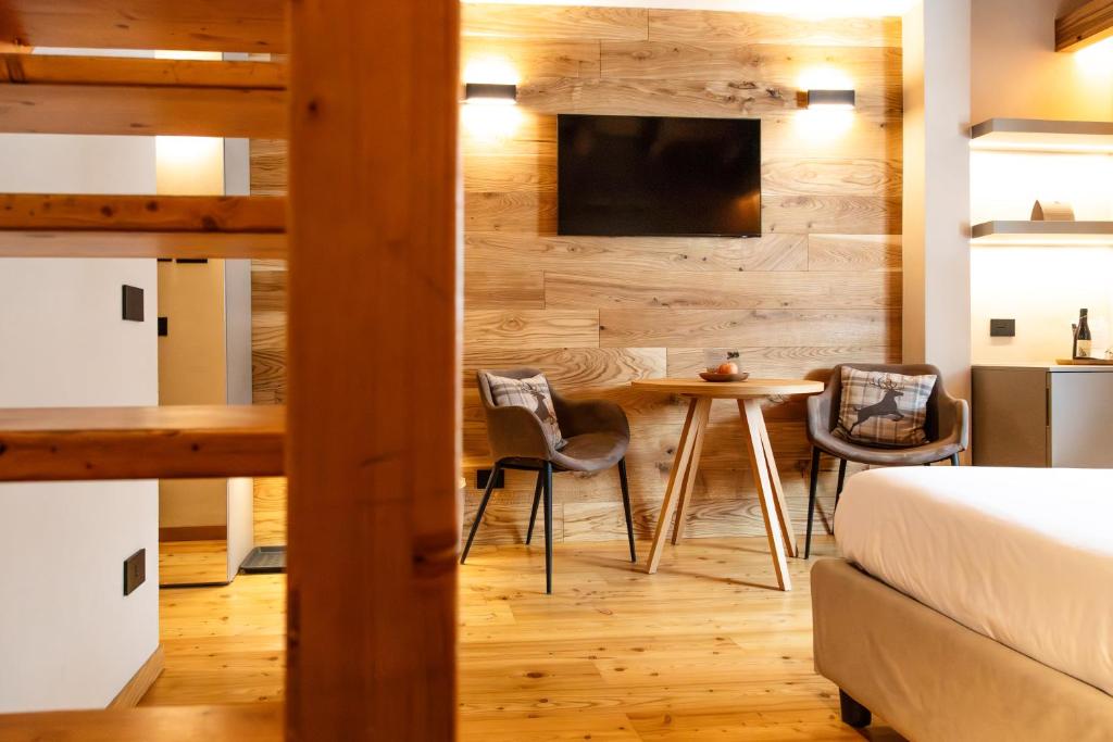 sypialnia z łóżkiem, stołem i krzesłami w obiekcie Hotel Relais Des Glaciers - Adults Only w mieście Champoluc