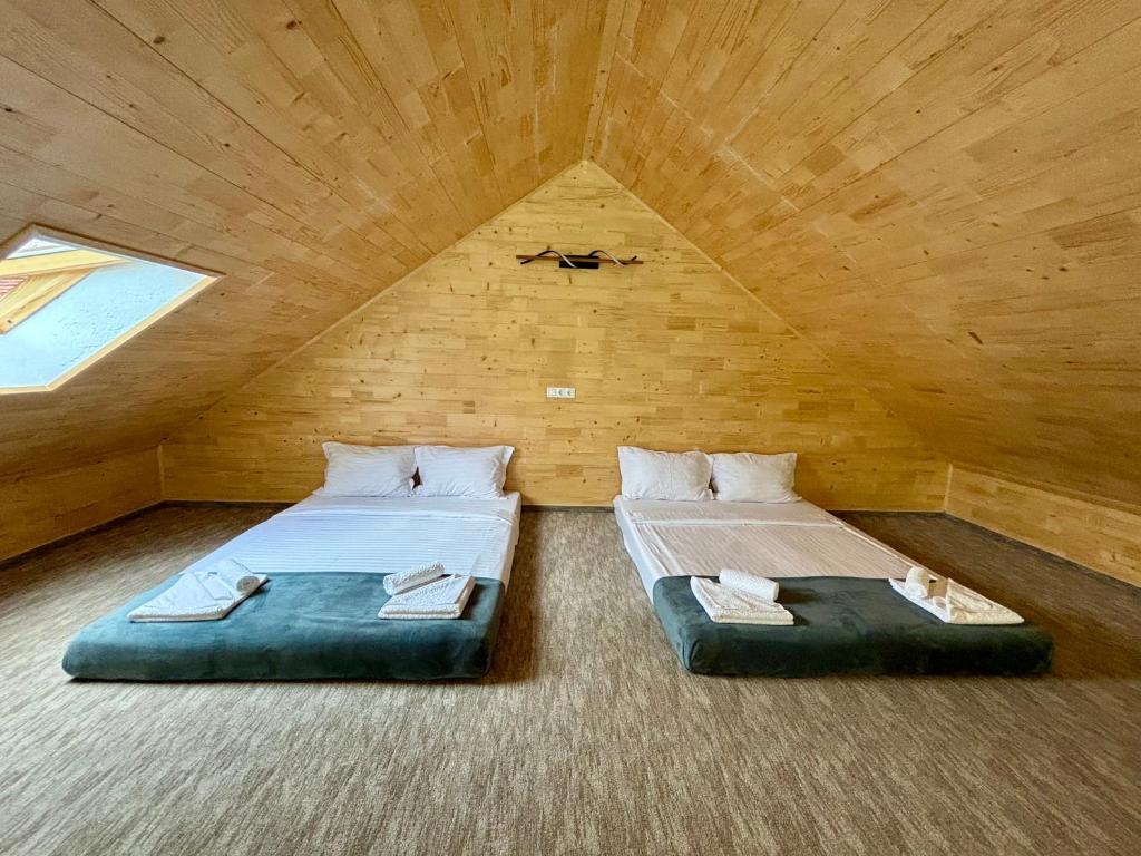 two beds in a room in a attic at Casa Tinca 2 in Izvoru Mureşului