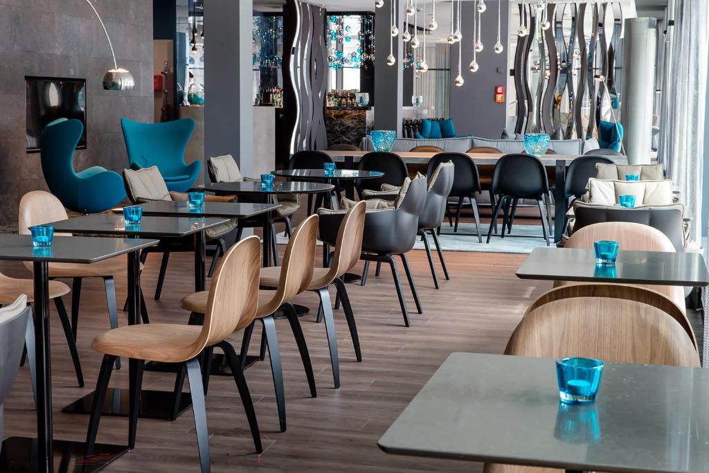 una sala da pranzo con tavoli e sedie di Motel One Stuttgart-Bad Cannstatt a Stoccarda