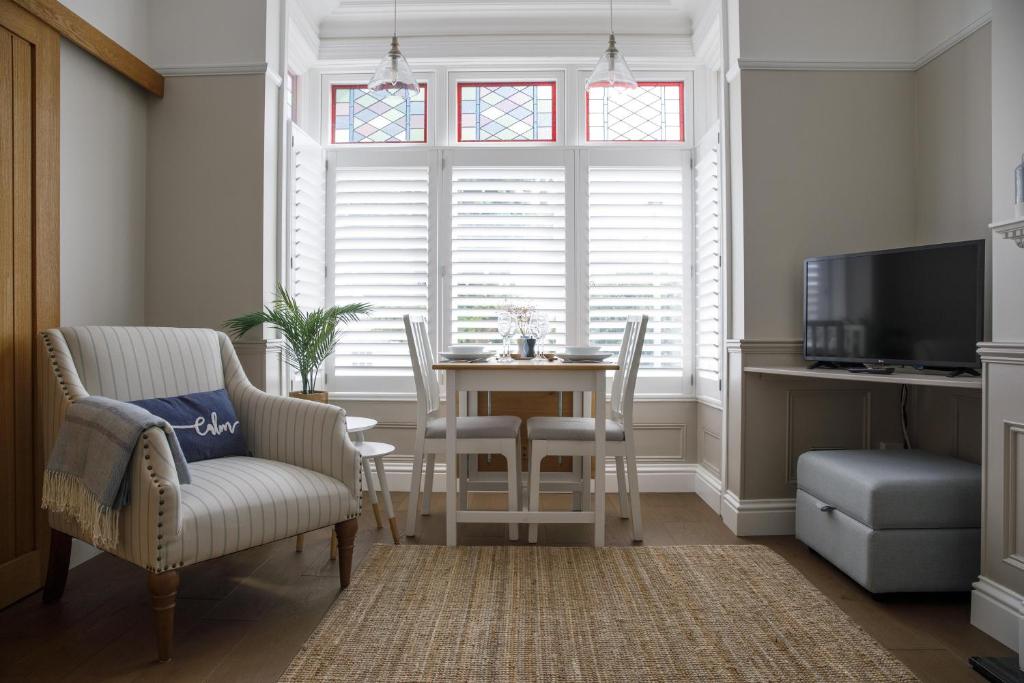 a dining room with a table and chairs and a window at Grove Apartment with Free on street Parking in Worthing