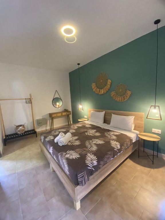 ein Schlafzimmer mit einem großen Bett und einer grünen Wand in der Unterkunft Euphoria ComplexB in Kavos