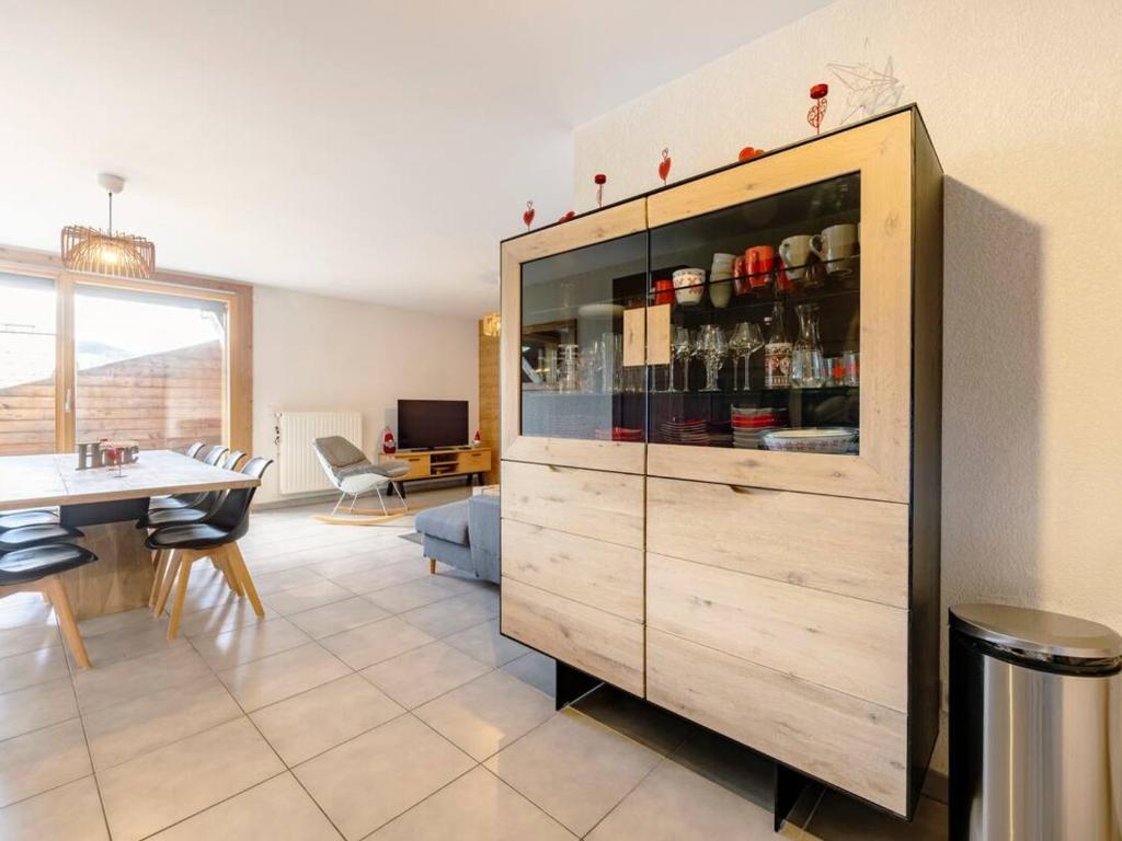un grand meuble en bois dans un salon avec une table dans l'établissement Spacieux appartement avec Wi-Fi et garage - FR-1-671-241, aux Gets