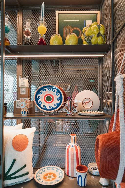 a shelf filled with plates and dishes on top at Hôtel de La Plage in Biarritz