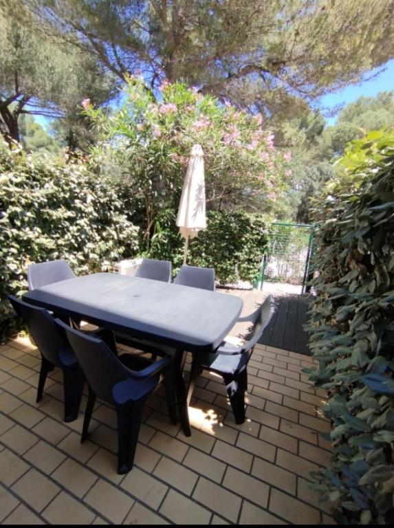 - une table, des chaises et un parasol sur la terrasse dans l'établissement Rez-de-jardin climatisé, à La Londe-les-Maures