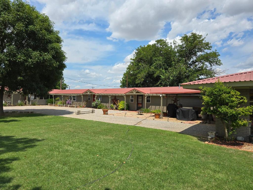 a building with red roofs and a grass yard at Roots Retreat in Seymour