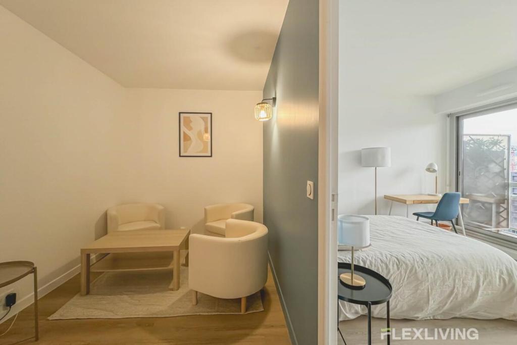 a bedroom with a bed and a table and chairs at Flexliving - room - Clichy la Garenne in Clichy