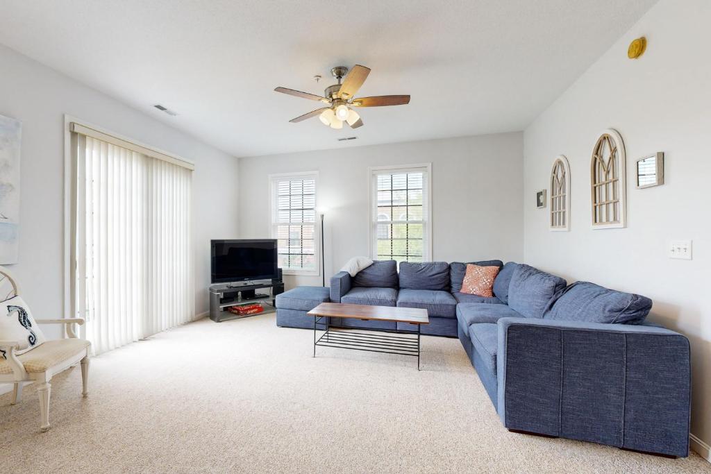 a blue couch in a living room with a ceiling fan at Village of Five Points --- 33322 E Chesapeake St UNIT 46 in Lewes