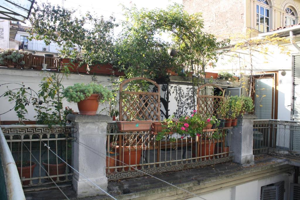 una recinzione con piante in vaso sul lato di un edificio di Albergo Avalon a Torino