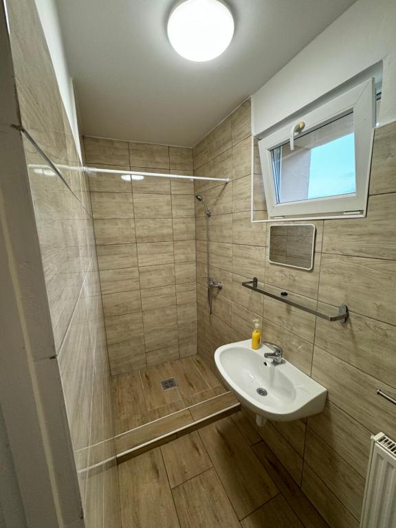 a bathroom with a sink and a shower at Széchenyi vendégház in Sajószöged