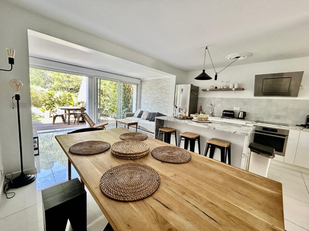 Il comprend une cuisine et un salon avec une table en bois. dans l'établissement Les Restanques Maison 26 pinède 3 chambres, à Grimaud
