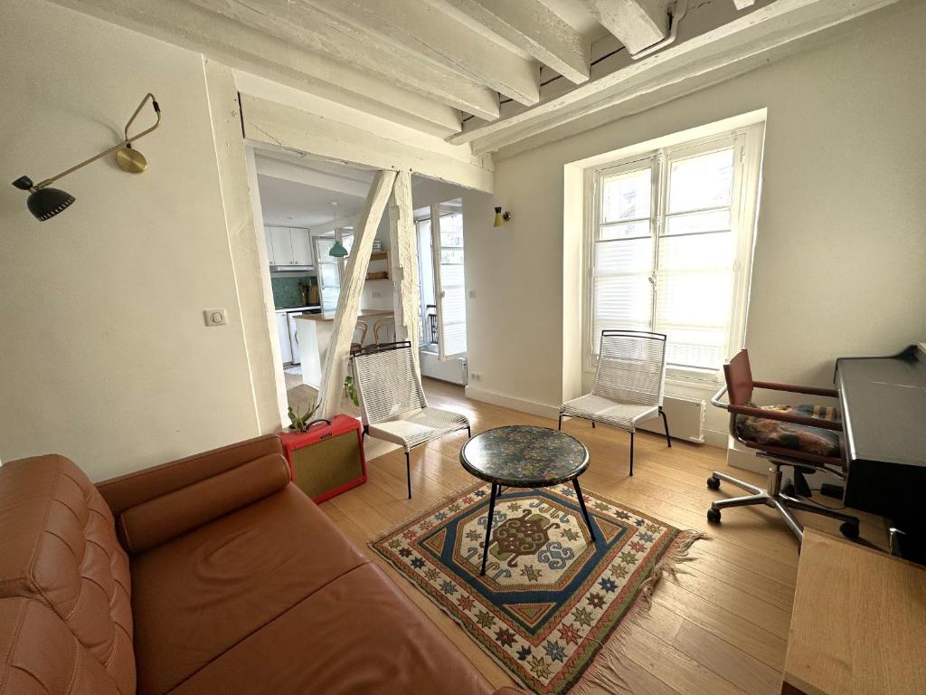 un salon avec un canapé et des chaises dans l'établissement Joli studio Jardin des Plantes, à Paris