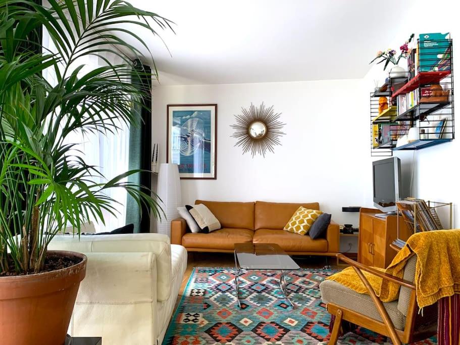 un salon avec un canapé et une plante dans l'établissement Chic and peacefull Parisian flat, à Paris