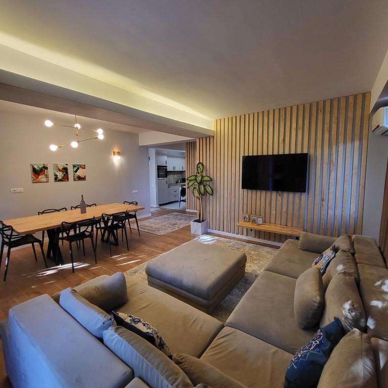 a living room with a large couch and a table at Apartament elegant cu terasă in Bucharest