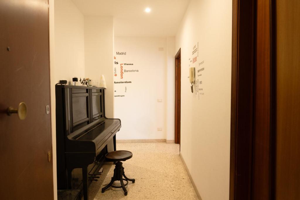 a hallway with a piano and a stool in a room at Catania ti aspetta2 in Catania