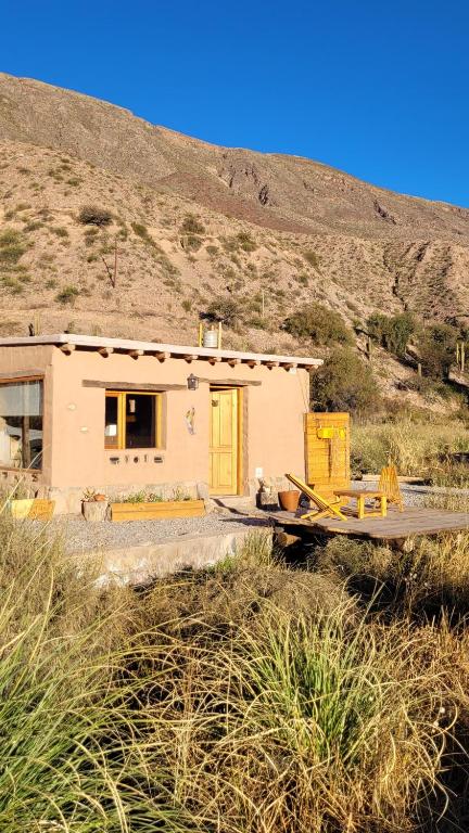 a small house with a yellow door in a field at Las Ranas in Tilcara