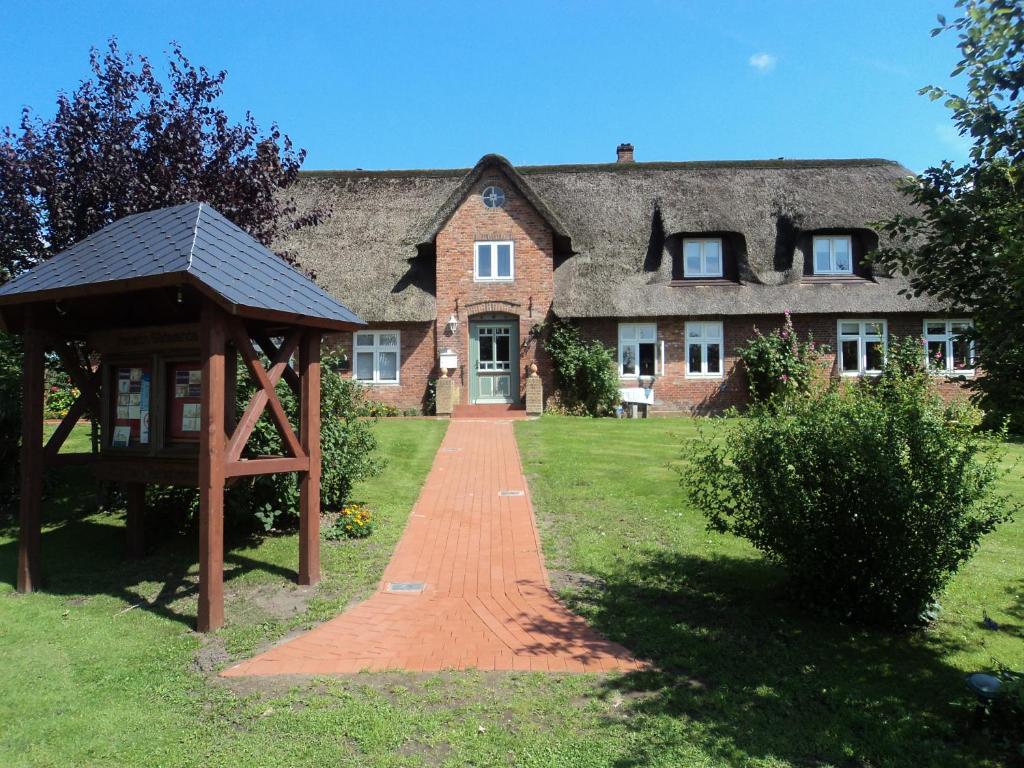 ein großes Backsteinhaus mit einem Weg davor in der Unterkunft Haus Süderende in Niebüll