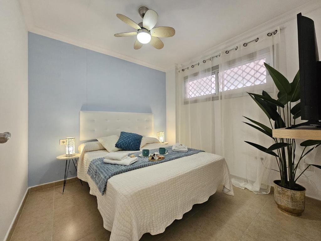 Un dormitorio con una cama con ventilador de techo. en Casa Cristina - Playa San Juan, en Playa de San Juan