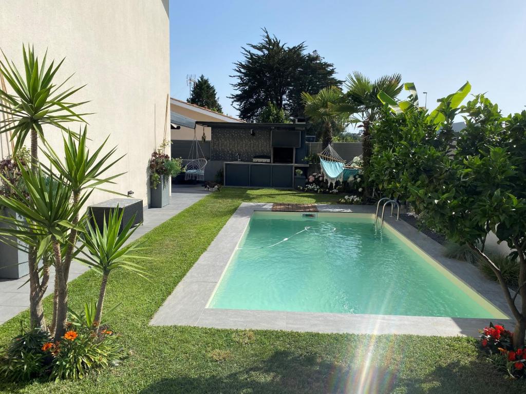 une piscine dans une cour à côté d'une maison dans l'établissement Maison avec piscine, à Tarnos