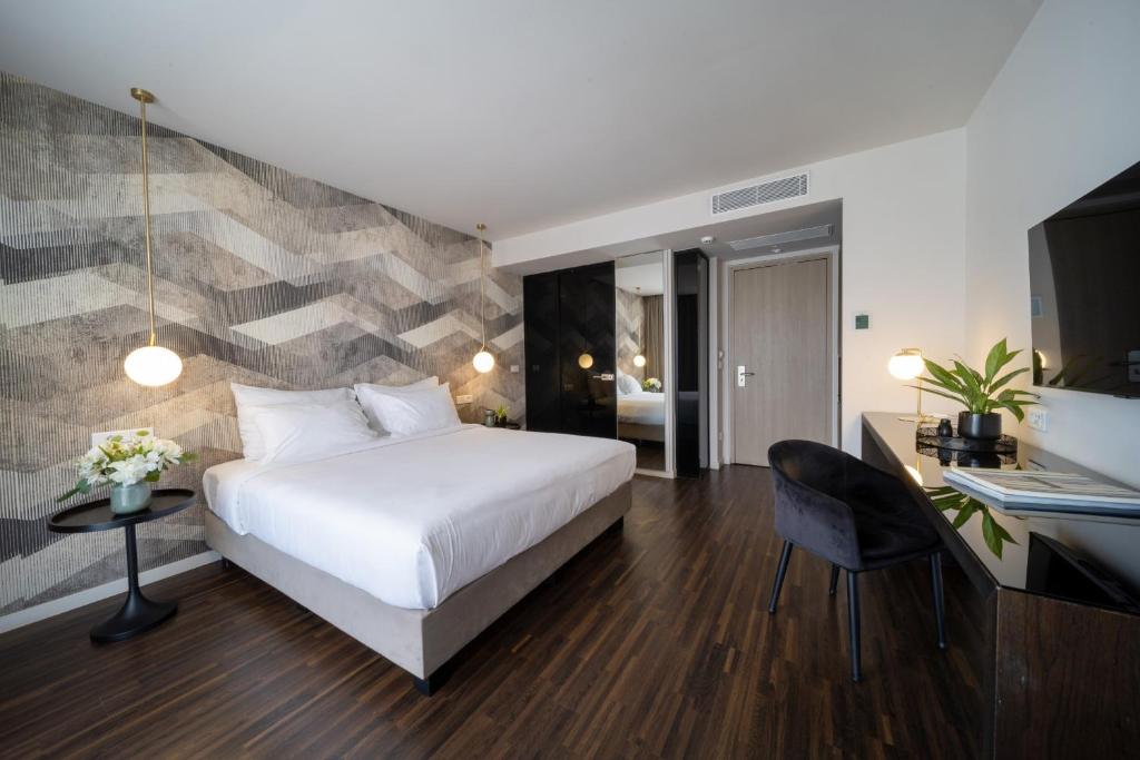 a bedroom with a bed and a desk with a laptop at Azur Hotel in Athens