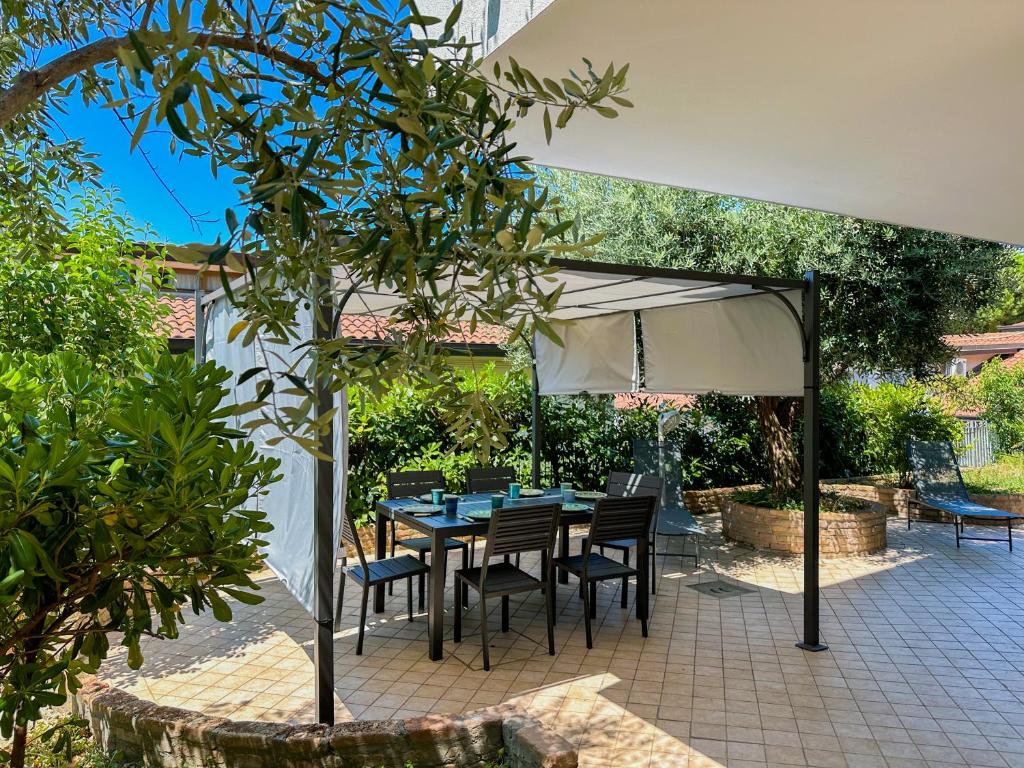 a patio with a table and chairs under an umbrella at Gio' Garden in Gabicce Mare
