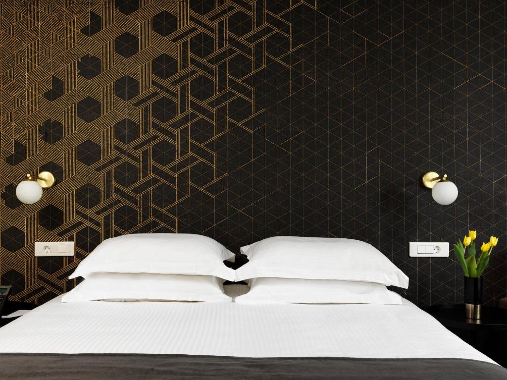 a bedroom with a bed and a black wall at Azur Hotel in Athens
