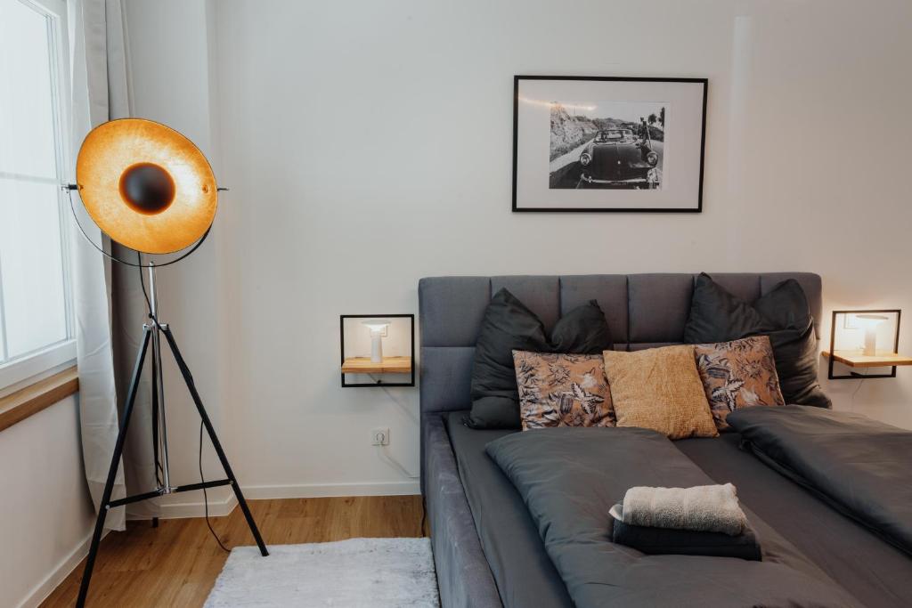 パッサウにあるCityHeart Appartement - Stadt Mitte - Stilvollのリビングルーム(グレーのソファ、ギター付)