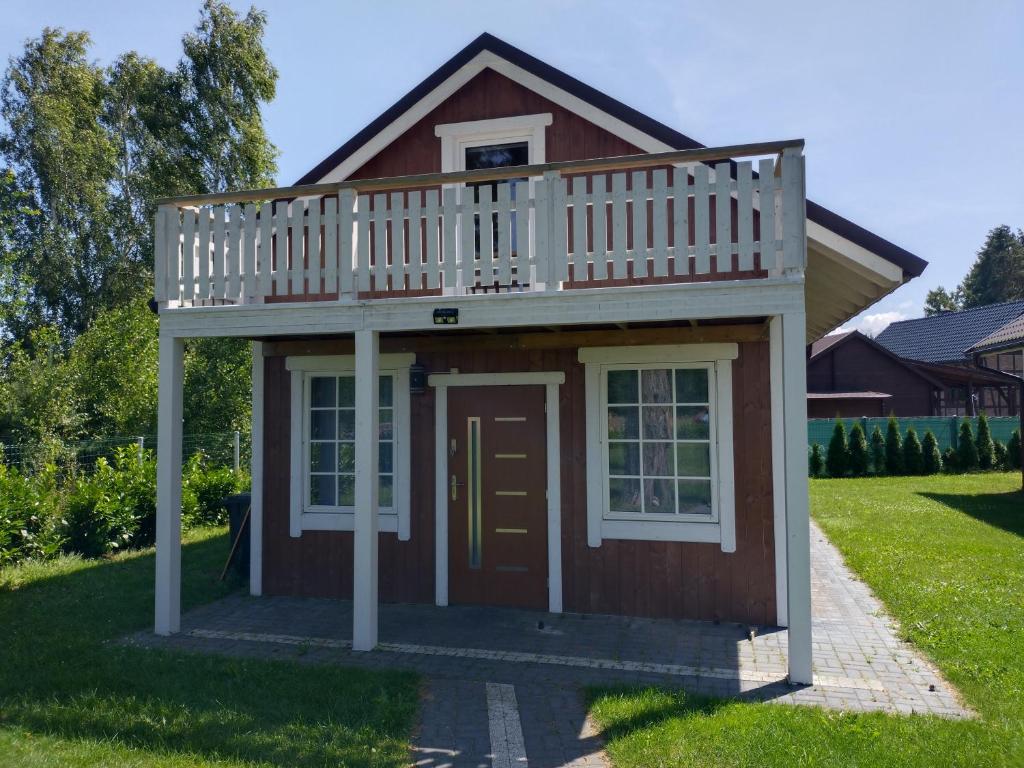 a dog house with a deck on top of it at Domek Borsuk in Kołczewo