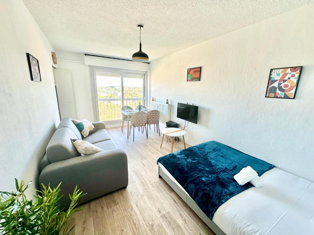 un salon avec un lit et un canapé dans l'établissement Le Baudin avec vue sur Limoges, à Limoges