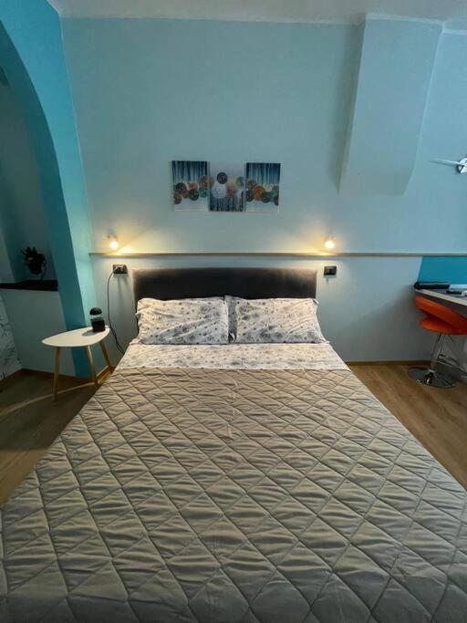a large bed in a bedroom with a blue wall at Perugia Home Apartment I Mille in Perugia