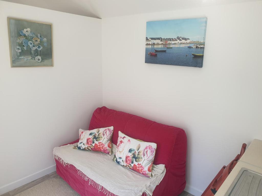 a red couch in a room with two pillows at Kays Cottage in Galway