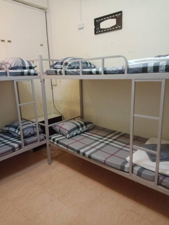 a room with three bunk beds in a dorm room at มังกรเลโฮสเทล Mangkonlay Hostel in Ban Khlong Pak