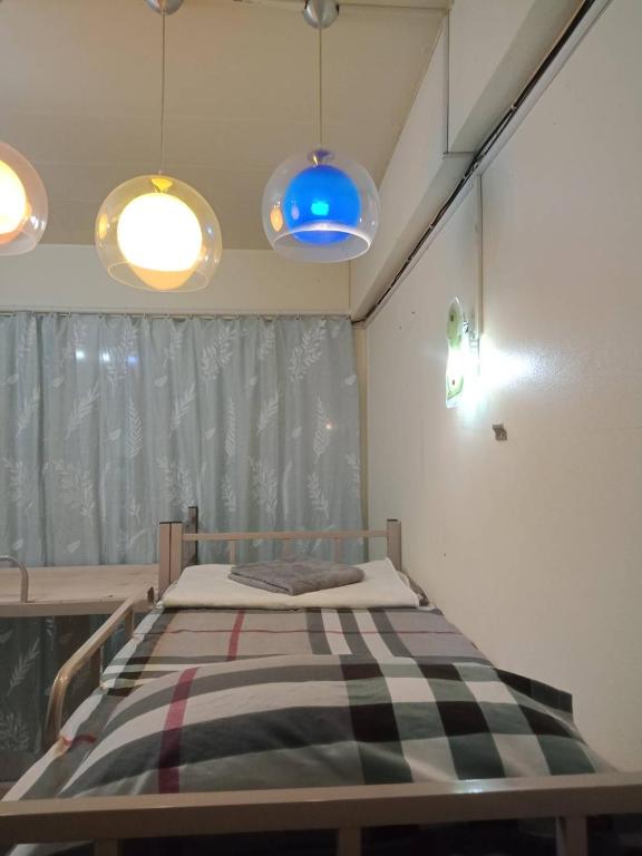 a bed in a room with two pendant lights at มังกรเลโฮสเทล Mangkonlay Hostel in Ban Khlong Pak
