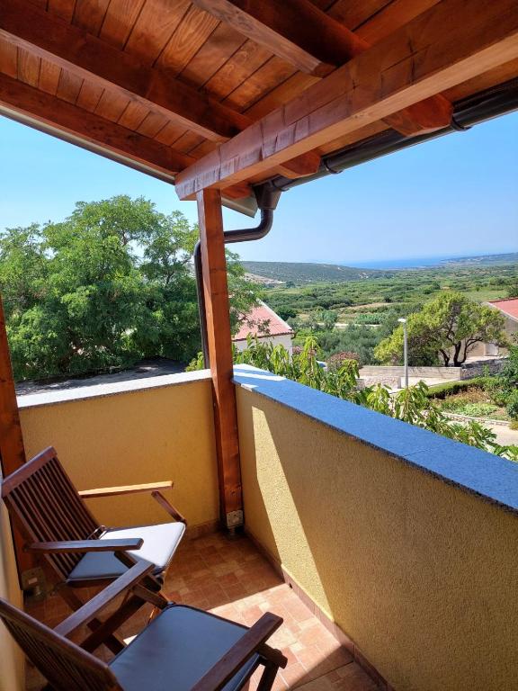 a balcony with two chairs and a view at Tina in Kolan