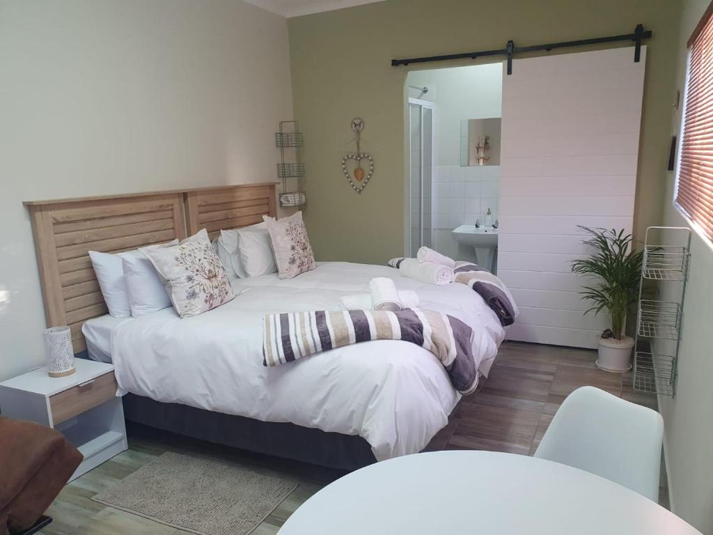a bedroom with two beds and a mirror at Humble & Kind Guest House in Oudtshoorn
