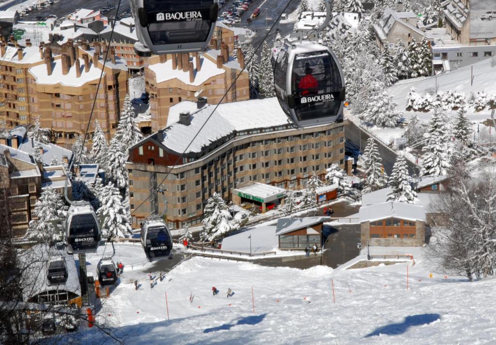 une remontée mécanique dans une ville avec des bâtiments enneigés dans l'établissement Tuc Blanc, à Baqueira-Beret