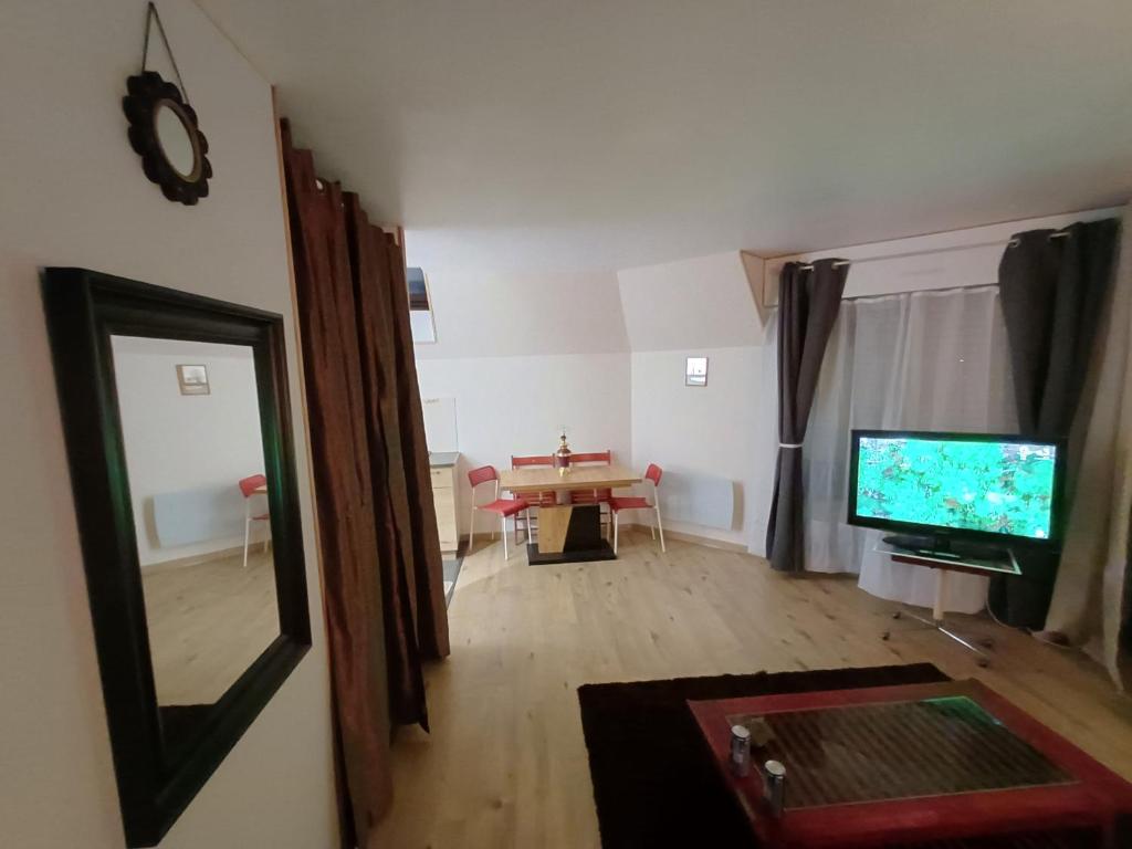 un salon avec une télévision et une table dans l'établissement Appartement indépendant Proche Paris, Roissy CDG, Astérix, Disneyland, à Mitry-Mory