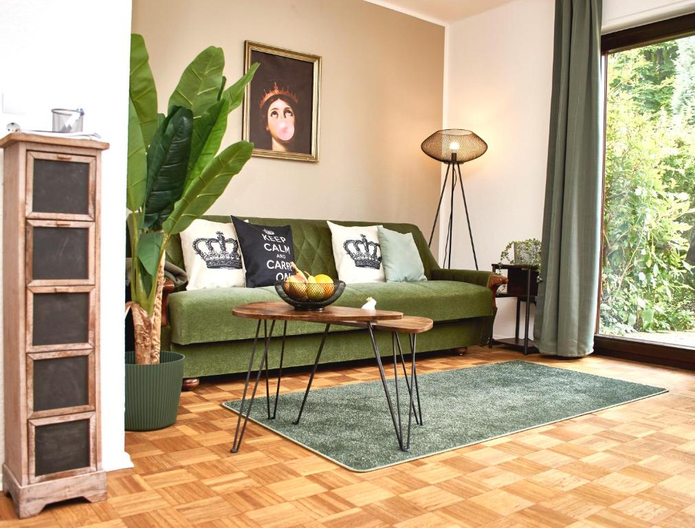 a living room with a green couch and a table at Femo - Royal Siegen - königliche Wohnung - separater Eingang - Oberstadt nähe Marienkrankenhaus in Siegen