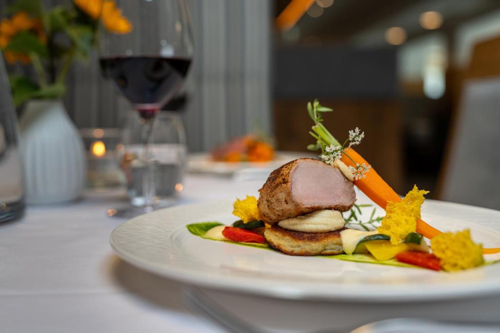 a white plate with a piece of food on a table at Hotel Tyrolerhof in Sölden