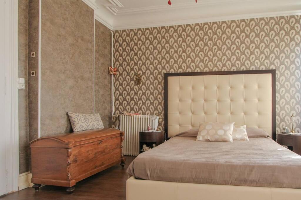 a bedroom with a large bed and a dresser at Villa Alba avec piscine et Spa in Metz