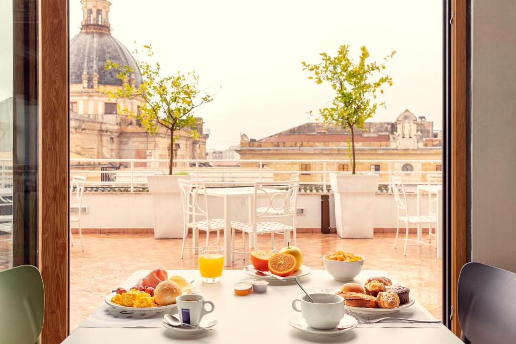 uma mesa com comida para o pequeno almoço com vista para a cidade em B&B Hotel Palermo Quattro Canti em Palermo