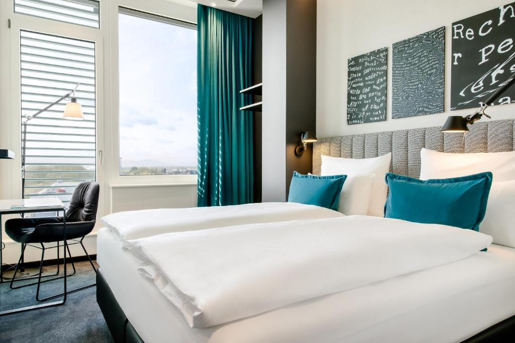 Postel nebo postele na pokoji v ubytování Motel One Karlsruhe
