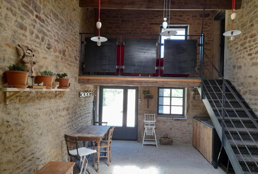 une mezzanine avec un escalier, une table et des chaises dans l'établissement At The End Of The World -bussieres Burgundy, à Bussières