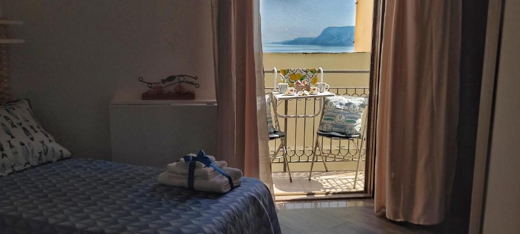 una camera da letto con un letto e una porta su un balcone di BELVEDERE apartment a Scilla