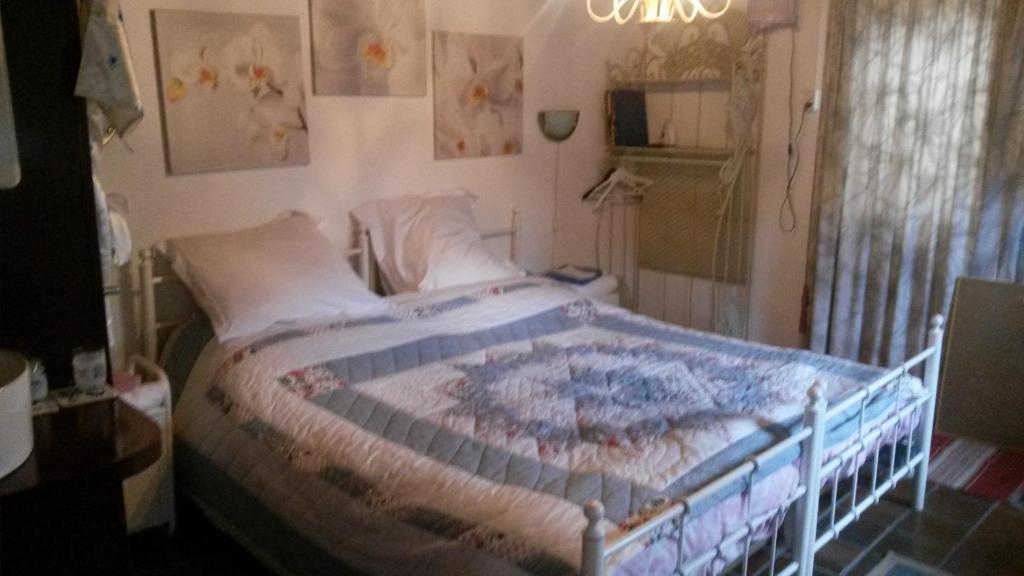 een slaapkamer met een bed met een quilt bij B&B aan de Limes in Maurik in Maurik