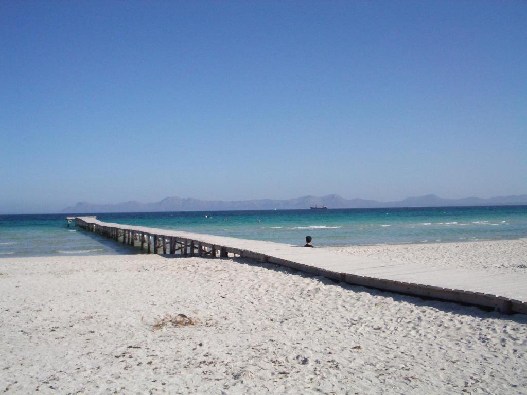 a person walking along a pier on the beach at Cas Ferrer Nou Hotelet in Alcudia