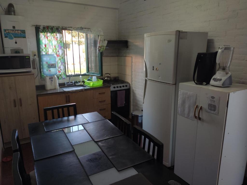 a kitchen with a table and a white refrigerator at Depto mina clavero Córdoba zona residencial in Mina Clavero