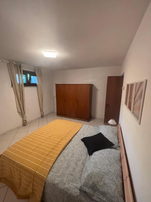 a bedroom with a large bed with a yellow blanket at Casa Zara - cozy home in the heart of Barga in Barga
