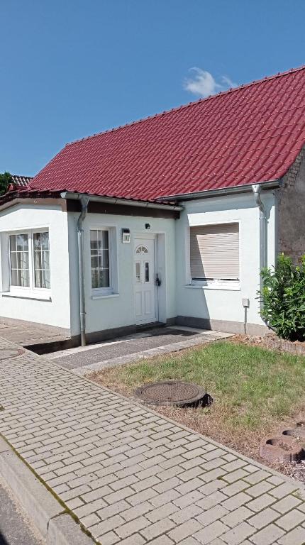 a small white house with a red roof at Gästewohnung Sommer Locktow, Hauptstraße 1 in Locktow